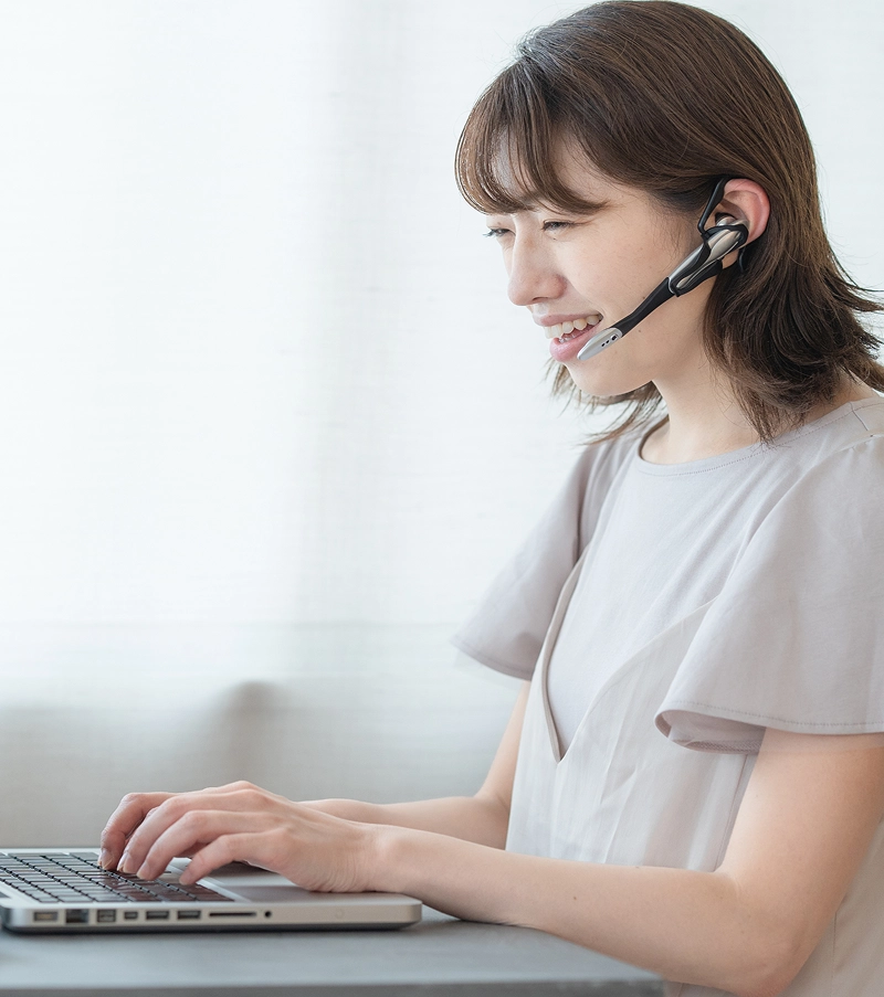 ヘッドセットを着用してクライアントとオンラインミーティングを行うWebデザイナー